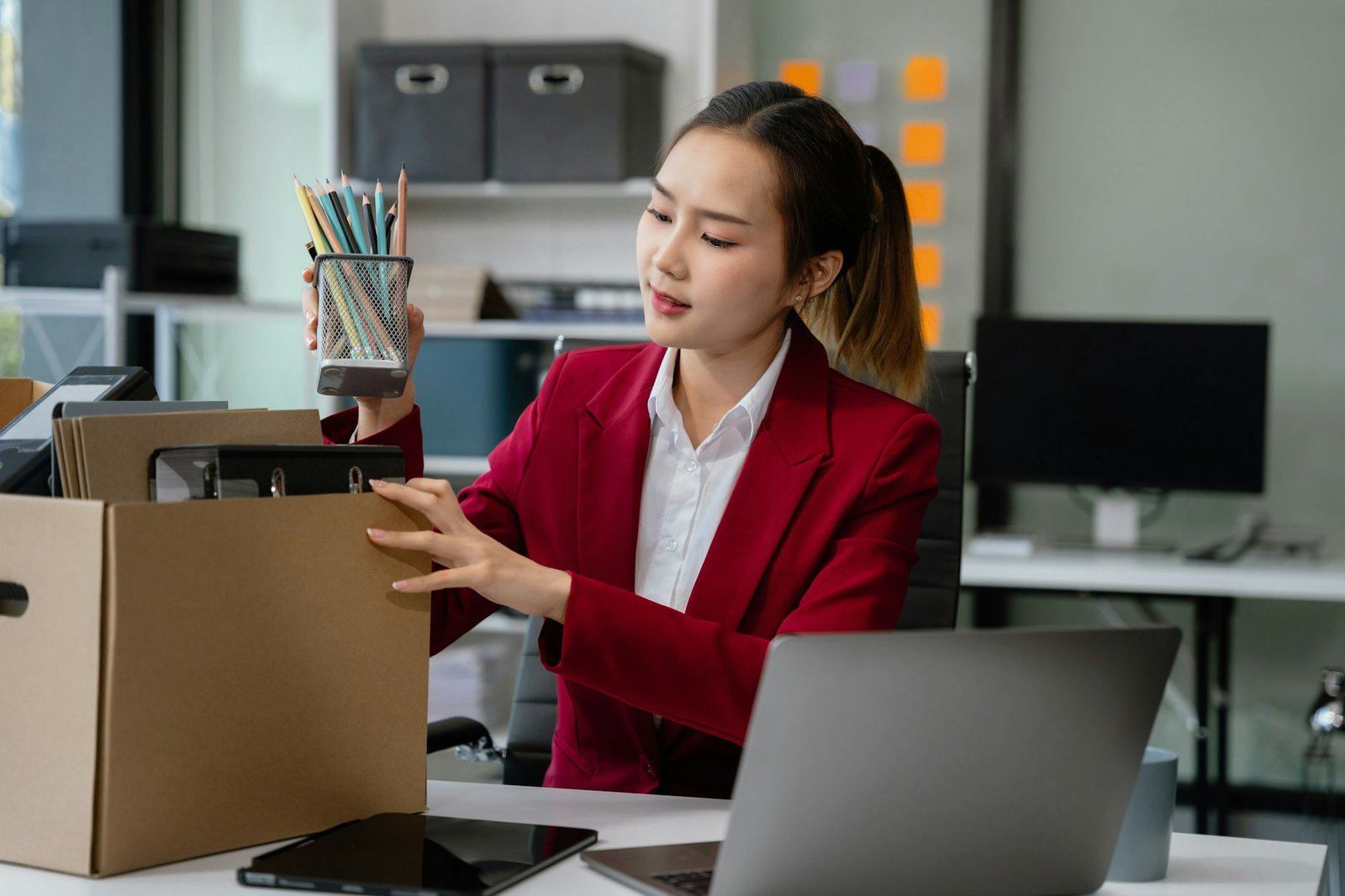 Businesswoman packing up in office, job promotion concept.